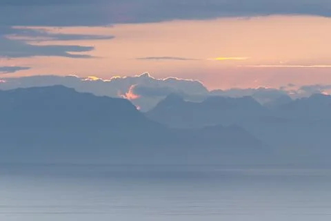 Coastal Mountain Range with Cloudy Sky at Sunrise Stock Photos