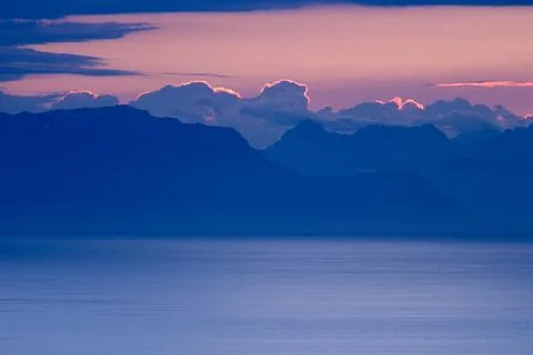 Coastal Mountain Range with Cloudy Sky at Sunrise Stock Photos