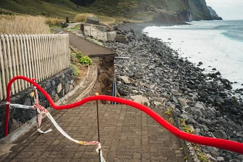 Coastal Path Damage: Eroded Walkway and Rocky Beach with Warning Tape and R.. Stock Photos