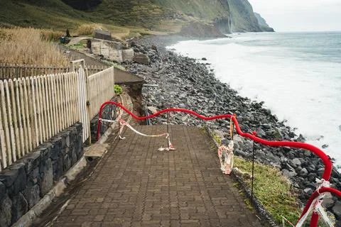 Coastal Pathway with Red Railing and Rough Ocean Waves on a Cloudy Day Outd.. Stock Photos