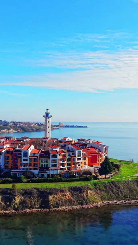 Coastal resort complex with lighthouse and red roofs Vertical video. Video stock 332343737