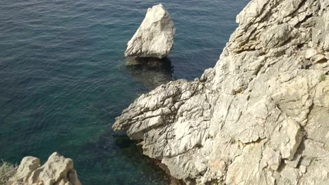 Coastal rock formations resting in calm Mediterranean sea Video stock 160981058