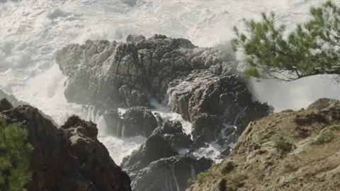 Coastal rocks submerged by large waves splashing Video stock 168772962