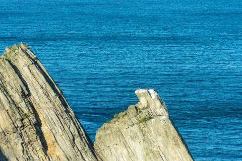 Coastal rocks triangular shape on the background of the sea. Foto stock