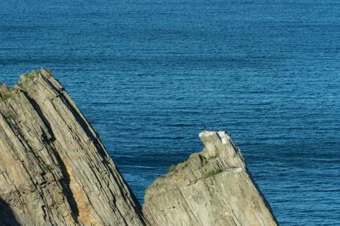 Coastal rocks triangular shape on the background of the sea. 스톡 사진