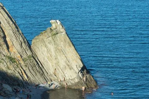 Coastal rocks triangular shape on the background of the sea. Stock Photos