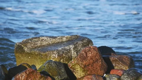 Coastal rocks with waves splashing under natural daylight by sea shore Stock Footage 333703143