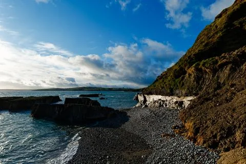 Coastal scenery with an eroding cliff face and sunlight Stock Photos