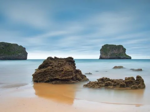 Coastal Sea Stack Monolith in Smooth Ocean - Long-exposure shot of a grass-.. Stock Photos