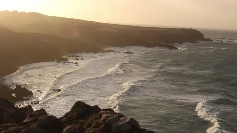 Coastal shot from cliffs of waves at sunset Stock Footage 274094129