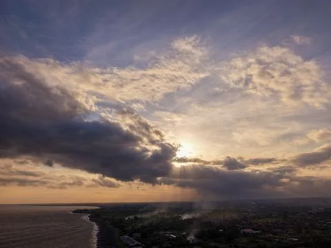 Coastal Sunset with Sun Rays Piercing Through Clouds Over Karangasem Bali Фото