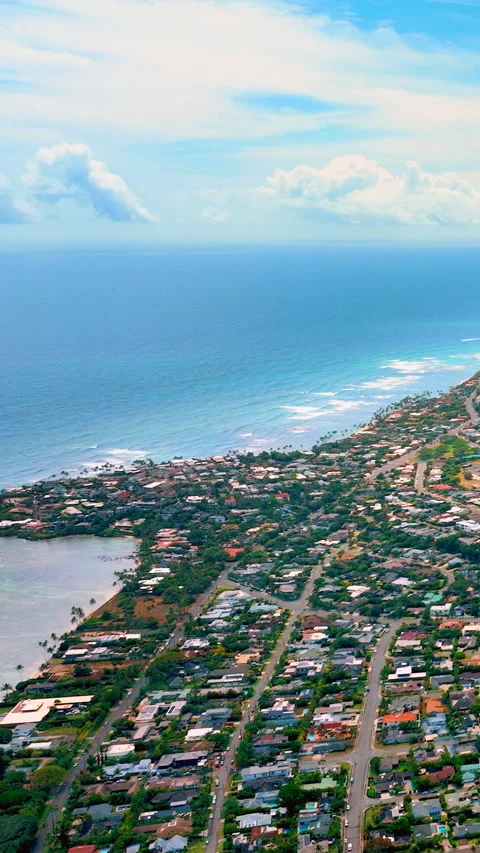 Coastal town with grid layout and waves crashing along the shore. Vertical Stock Footage 319759373