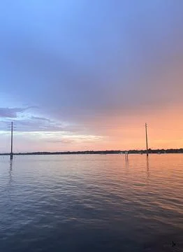 Coastal Twilight Sky Split with Utility Poles over Open Water Stock Photos