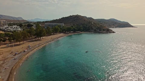 Coastal view of a beach in the afternoon with clear water and hills in the .. Stock Footage 340191732