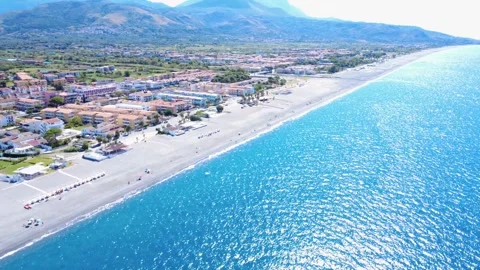 Coastal View of Beach and Ocean With People Enjoying Sunny Day Near Town in Stock Footage 322935125