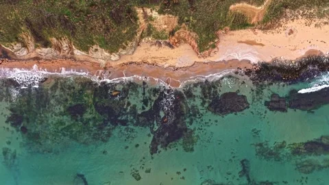 Coastal view captured from above showcasing sandy beach and clear water Stock Footage 327143701