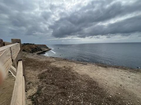 Coastal View Features Rugged Cliffs and a Cloudy Sky Over the Ocean Stock Photos