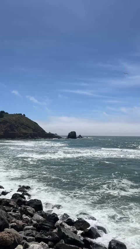 Coastal view featuring rugged cliffs and crashing waves on a sunny day Stock Footage 286729119