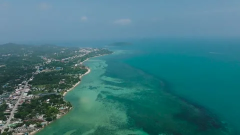 Coastal village surrounded by lush greenery and turquoise waters. Ko Pha Ngan Stock Footage 310780296