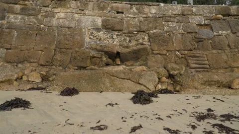 Coastal wall in a yellow beach, camera moving left to the right. Yellow Stock Footage 255308529