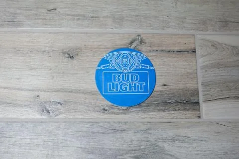 A coaster for Bud Light Beer on a light wood tile background Stock Photos