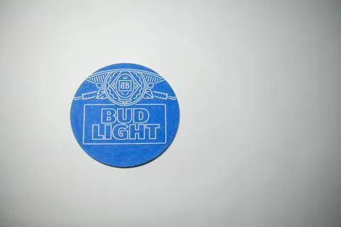 A coaster for Bud Light Beer on a light wood tile background Stock Photos