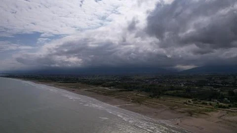Coastline and surf beneath a dramatic cloud bank Stock Photos