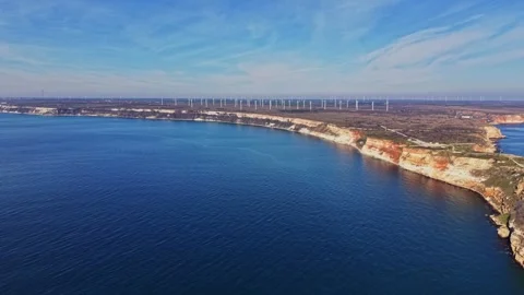 Coastline with cliffs and wind turbines under blue sky 動画素材 336543237