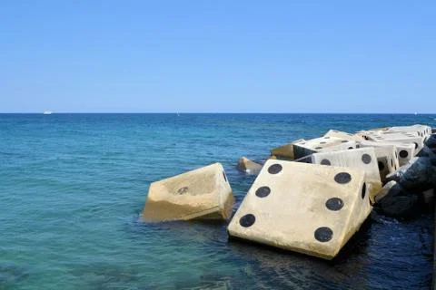 Coastline with concrete wave breaker in the shape of dice Stock Photos