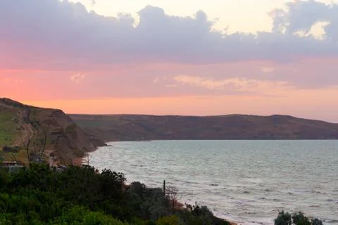 Coastline of the sea in the rays of the setting sun Stock Photos