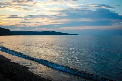 Coastline of the sea in the rays of the setting sun Stock Photos