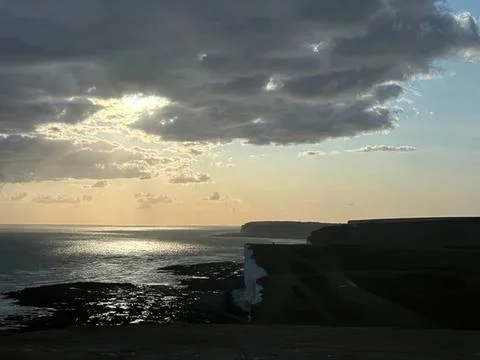 Coastline at sunset with cliffs and cloudy sky Stock Photos