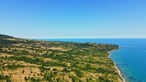 Coastline view from high ground showing land and sea under clear sky at midday Stock Footage 341124012