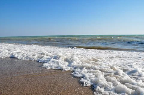 Coastline with waves rolling on the beach. Stock Photos