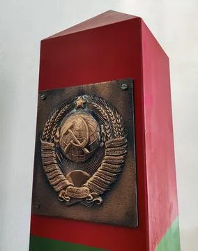 Coat of arms of the Soviet Union on the surface of typical border post that s Stock Photos