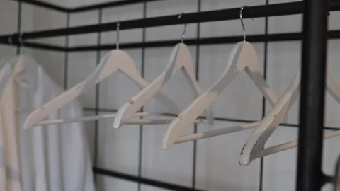 Coat rack with white hangers and hanging robes in a minimalist interior Stock Footage 313656521