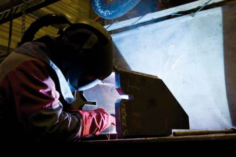Coated textile plant, maintenance workshop, welder performing arc welding Stock Photos