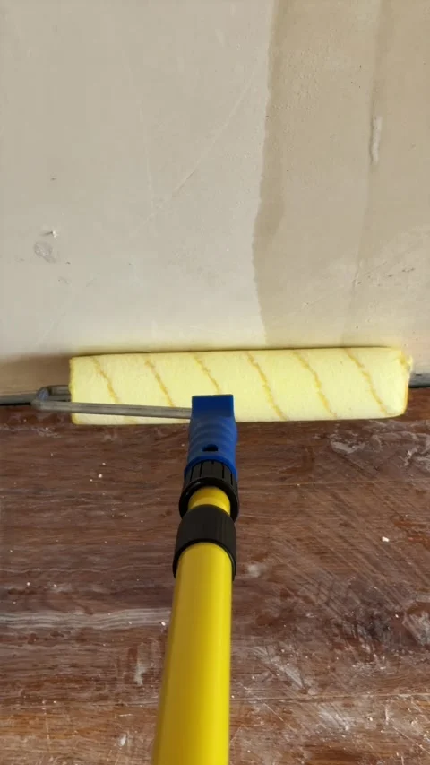 Coating bare wall with liquid primer using roller on telescopic pole Stock Footage 340404933
