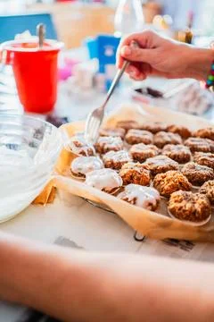 Coating a Batch of Cookie Macaroons with Sugar Glaze in the Christmas Bakery Foto stock