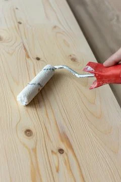 Coating the board with varnish using a roller Stock Photos