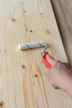 Coating the board with varnish using a roller Stock Photos