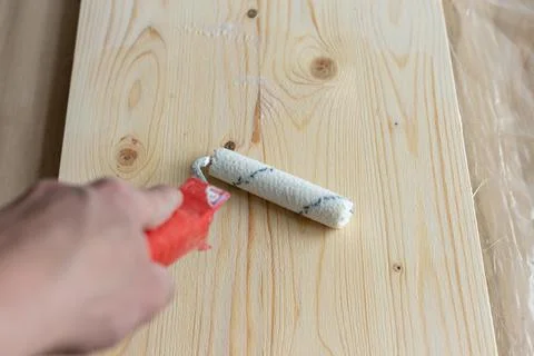 Coating the board with varnish using a roller Stock Photos
