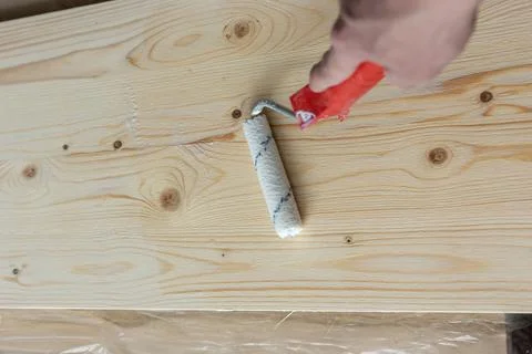 Coating the board with varnish using a roller Stock Photos