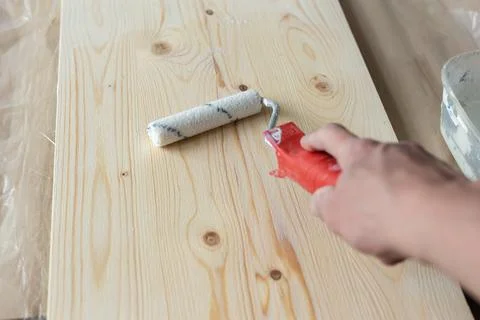 Coating the board with varnish using a roller Stock Photos