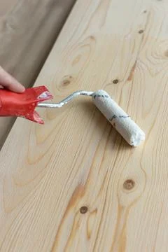 Coating the board with varnish using a roller Stock Photos