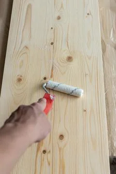 Coating the board with varnish using a roller Stock Photos
