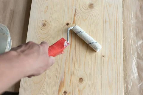 Coating the board with varnish using a roller Stock Photos