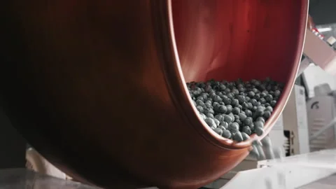 Coating of caramel sweets in a drum at a confectionery factory. Stock Footage 278415599