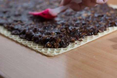 Coating chocolate topping with wallnuts on cake crust Stock Photos