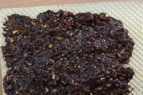 Coating chocolate topping with wallnuts on cake crust Stock Photos